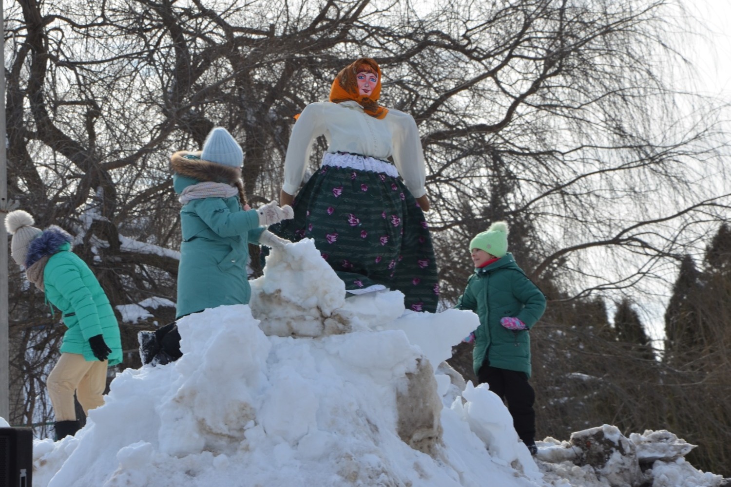 Дети веселились на снежной горке возле Масленицы