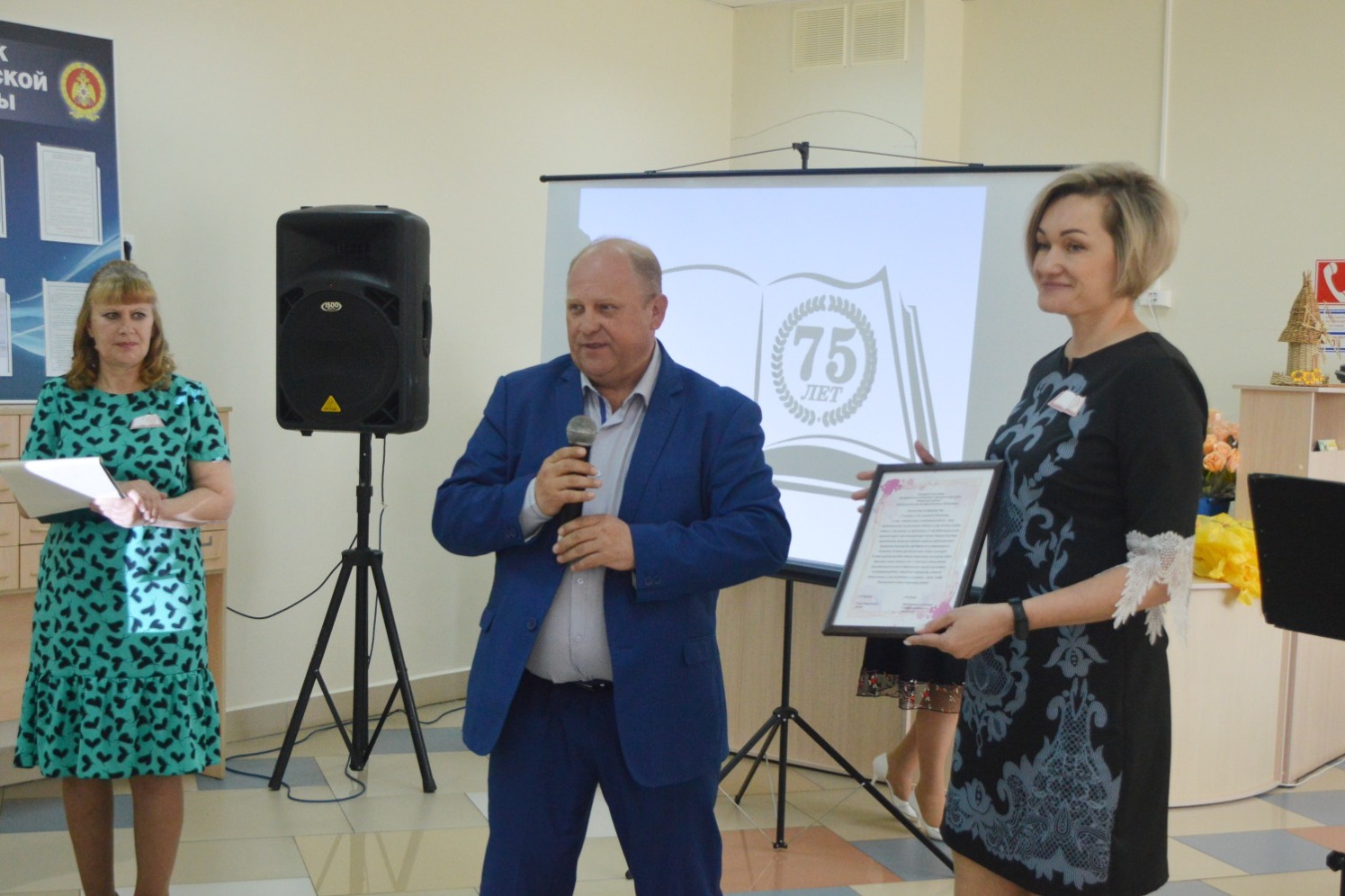 Сергей Ефанов вручает поздравительный адрес директору межпоселенческой централизованной библиотеки Ирине Носиковой