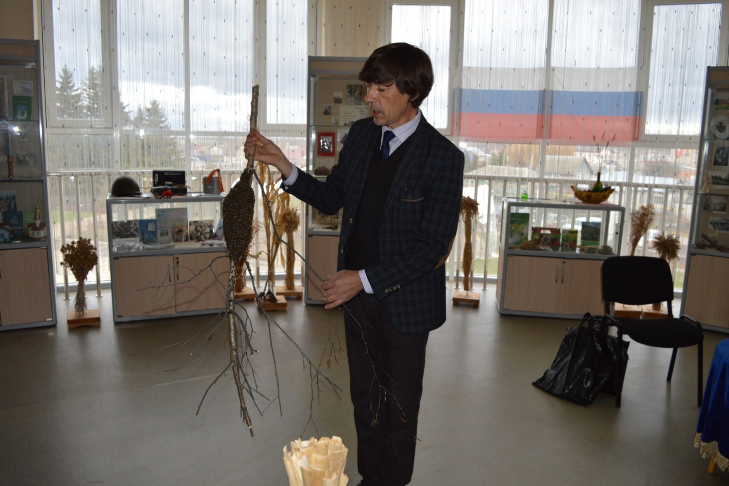 Андрей Алексеевич держит в руках новый экспонат школьной музейной комнаты – пчелиный рой на ветке