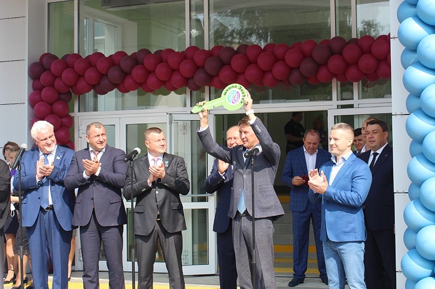 Директор школы Александр Кочетков демонстрирует символический ключ от нового учебного заведения