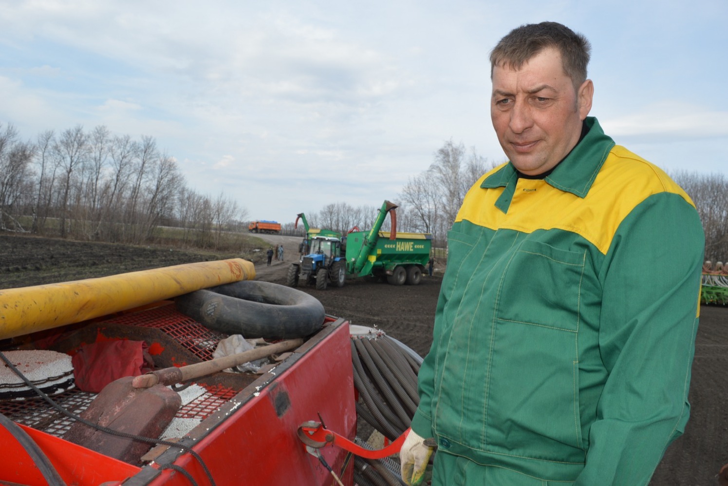 Александр Кирюшин следит за семенами гороха в сеялке