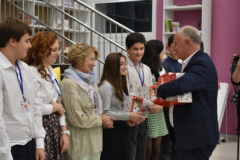 Глава Котовска Алексей Плахотников вручает на память гостям из Абхазии неваляшки