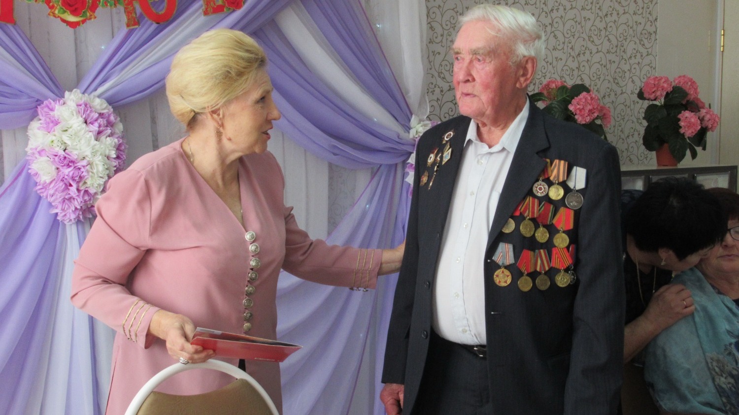 Александра Егоровича с 95-летием поздравляет председатель ветеранской организации Антонина Бросалина, 2019 год.