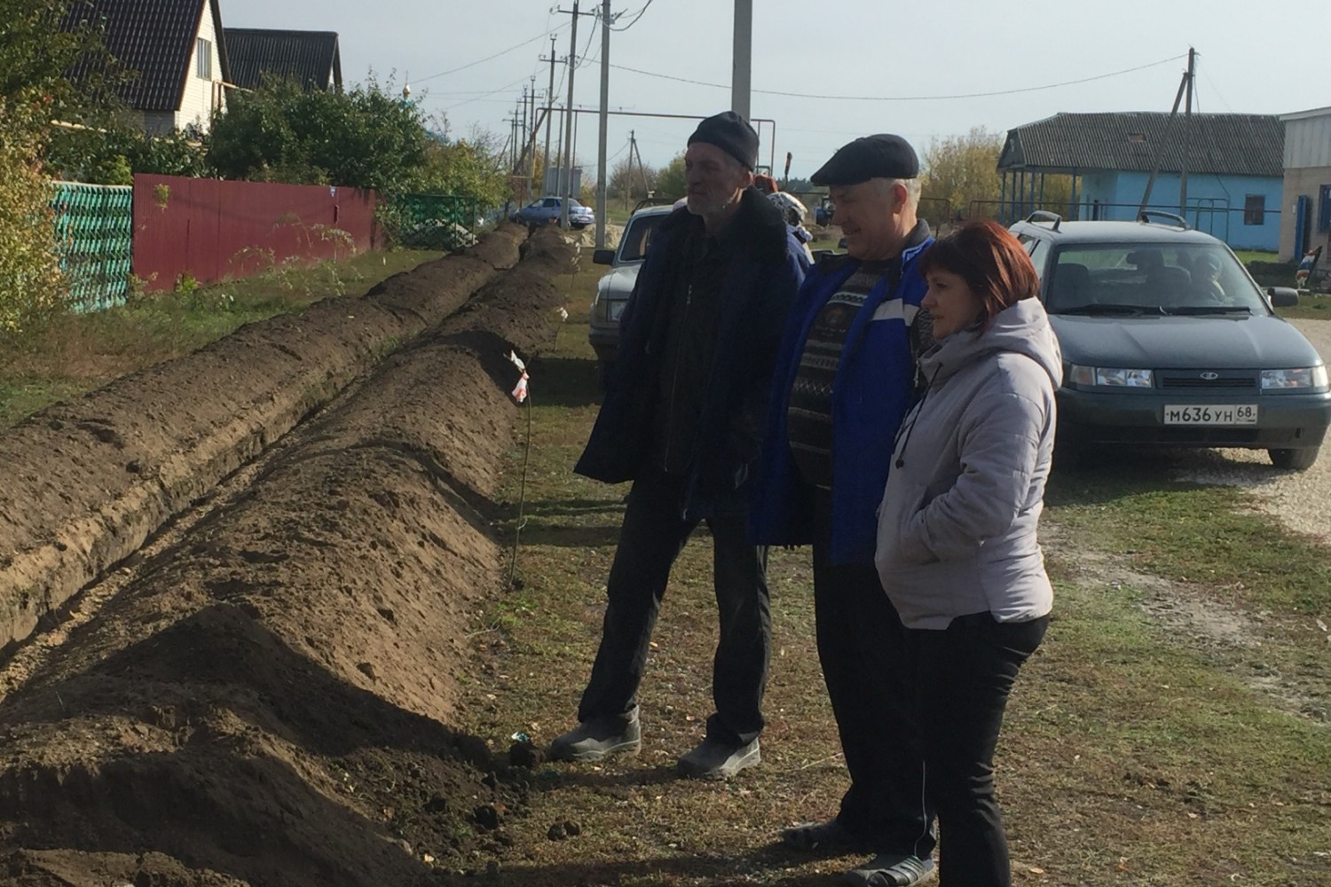 Сергей Дятчин (в центре) наблюдает за подключением к новому водопроводу своего дома